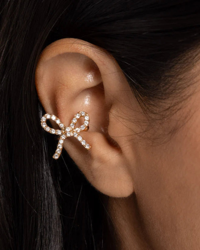 Convincing Charm - Gold White Rhinestone Bow Ear Cuff Earrings - Paparazzi